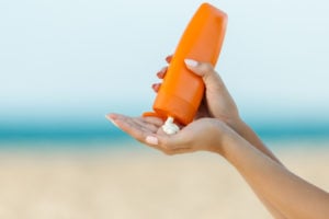 woman pouring sunscreen into hand