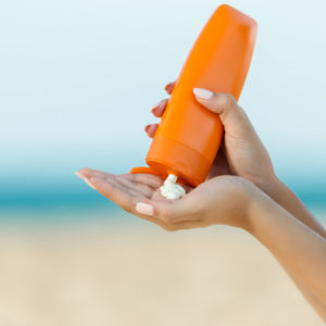 woman pouring sunscreen into hand