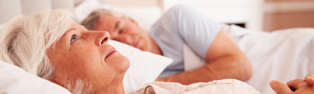 Photo of couple laying in bed.