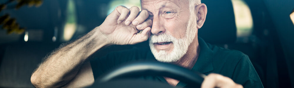 Image of person rubbing their eye while driving