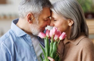 Mature couple in love man gives tulips ready for romance and sex