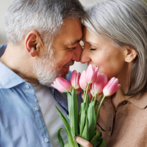Mature couple in love man gives tulips ready for romance and sex