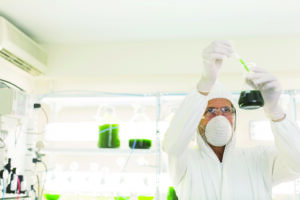 Scientist in clean suit conducting scientific experiment in laboratory