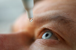 Man puts eyedrops into his eye