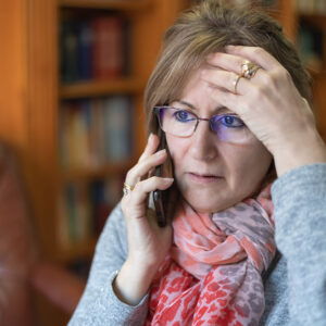 Senior woman on phone feeling stress.