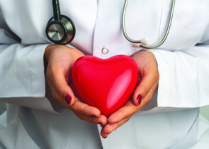 Medicine doctor holding red heart shape in hands.