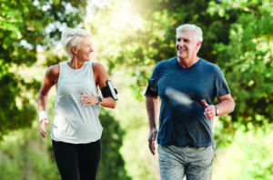 Healthy, happy senior couple jogging outdoors for exercise.