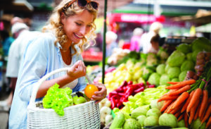 Woman holding a basket with healthy fresh organic vegetables