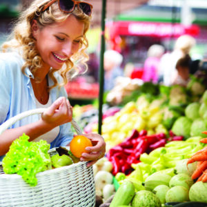 Woman holding a basket with healthy fresh organic vegetables