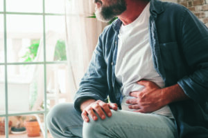 Man suffering holding abdomen with stomach pain