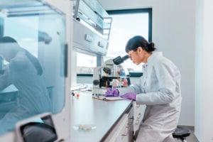 Female scientist looking through a microscope